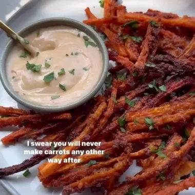 Baked crispy carrot fries served in a bowl with dipping sauce
