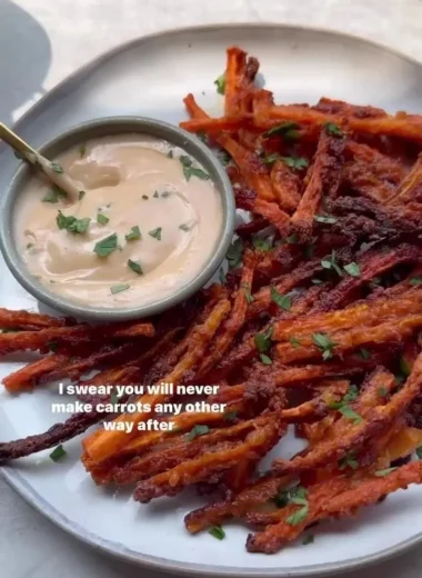 Baked crispy carrot fries served in a bowl with dipping sauce