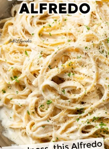 Homemade Alfredo sauce in a white bowl, garnished with parsley.