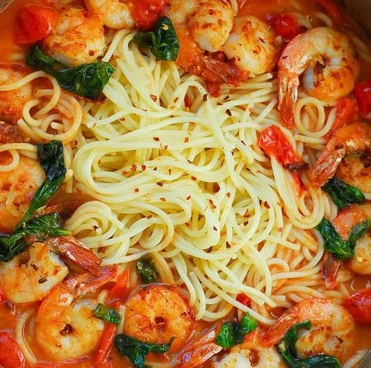 Shrimp pasta dish featuring garlic basil tomato sauce in a bowl
