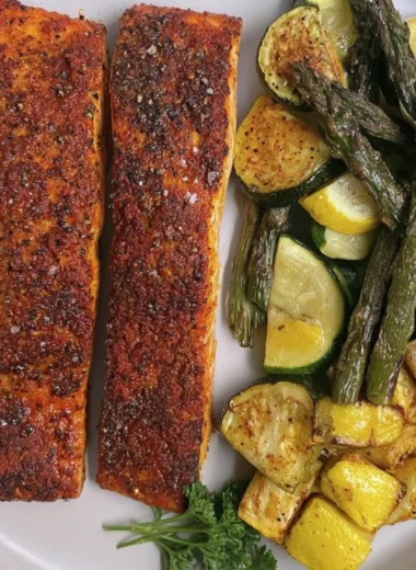 Delicious oven baked salmon served with herbs and lemon slices.