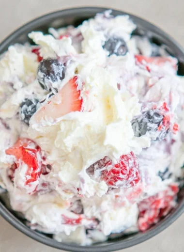 Delicious cheesecake salad served in a bowl with fresh fruit and toppings.