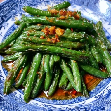 Chinese green beans stir fry served in a bowl with garlic and sesame seeds