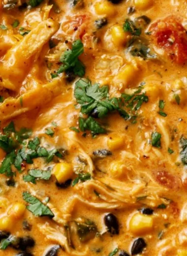 Bowl of creamy chicken tortilla soup topped with crispy tortilla strips and cilantro