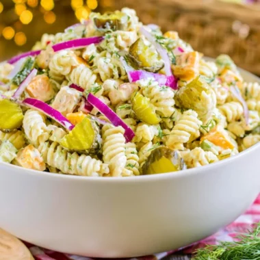 Creamy dill pickle macaroni salad in a bowl garnished with fresh dill.
