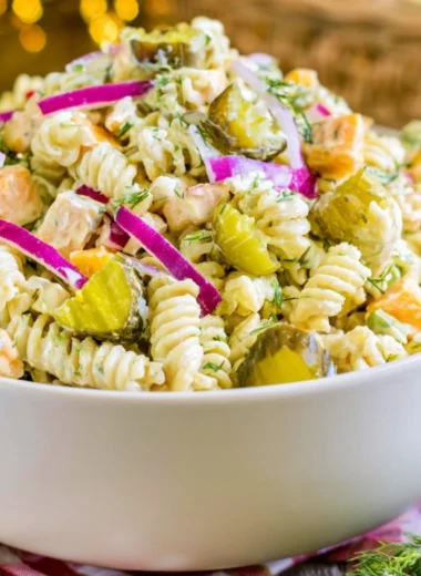 Creamy dill pickle macaroni salad in a bowl garnished with fresh dill.