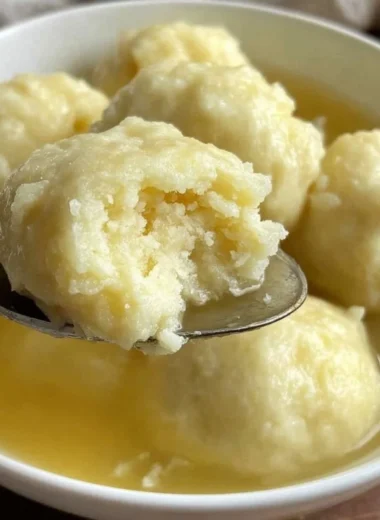 Fluffy drop dumplings cooking in a pot of savory soup