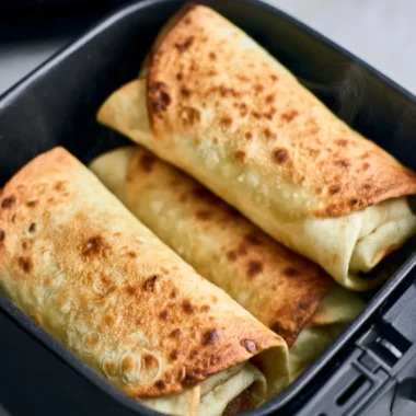 Delicious air fryer chimichangas on a plate with toppings.