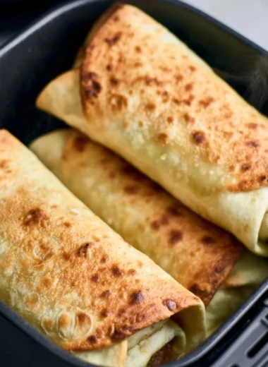Delicious air fryer chimichangas on a plate with toppings.