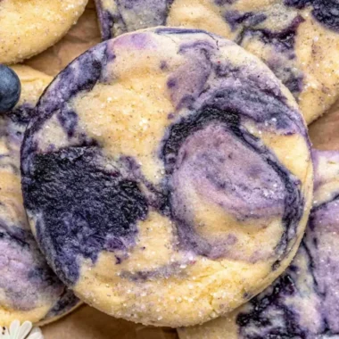 Lemon Blueberry Cheesecake Cookies on a plate, topped with blueberries