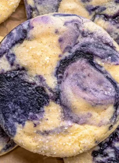 Lemon Blueberry Cheesecake Cookies on a plate, topped with blueberries