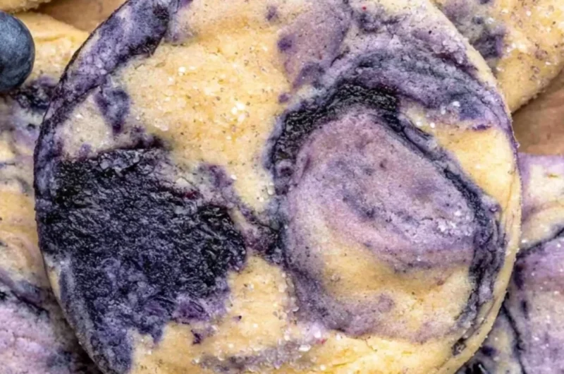 Lemon Blueberry Cheesecake Cookies on a plate, topped with blueberries