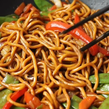Delicious bowl of Lo Mein noodles topped with fresh vegetables and savory sauce