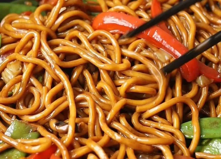 Delicious bowl of Lo Mein noodles topped with fresh vegetables and savory sauce