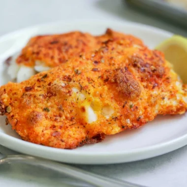 Delicious Parmesan Crusted Cod served with lemon garnish on a plate