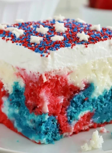 Patriotic poke cake with red, white, and blue layers for 4th of July celebration