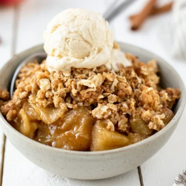 Bowl of delicious homemade apple crisp topped with ice cream