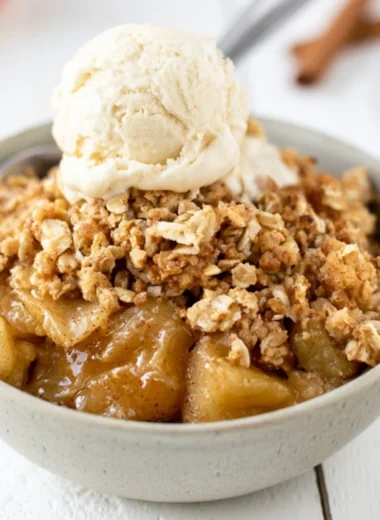 Bowl of delicious homemade apple crisp topped with ice cream