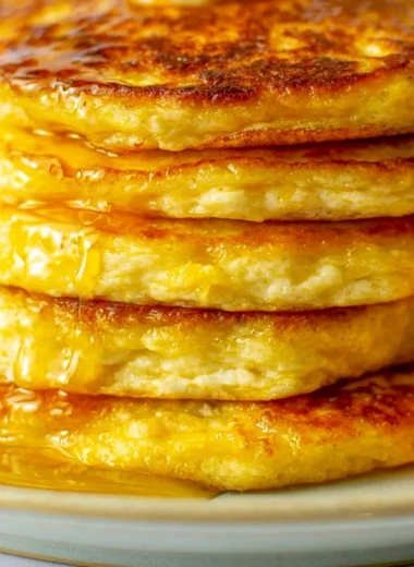 Cozy orange ricotta pancakes stacked with syrup and orange zest garnish