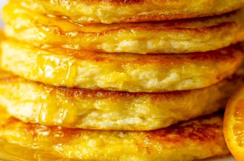 Cozy orange ricotta pancakes stacked with syrup and orange zest garnish