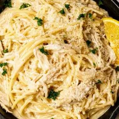 Creamy lemon chicken pasta with fresh herbs and lemon slices