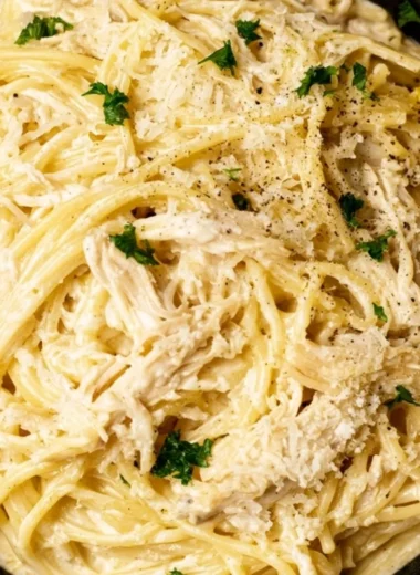 Creamy lemon chicken pasta with fresh herbs and lemon slices