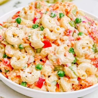 Delicious creamy macaroni salad served in a bowl with fresh herbs.