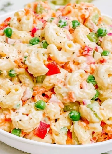 Delicious creamy macaroni salad served in a bowl with fresh herbs.