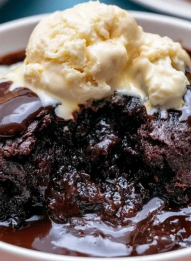 Delicious crockpot pudding brownies topped with chocolate drizzle and nuts.