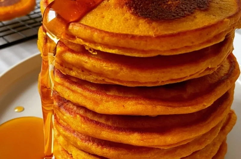 Cozy pumpkin cottage cheese pancakes stacked on a plate with maple syrup